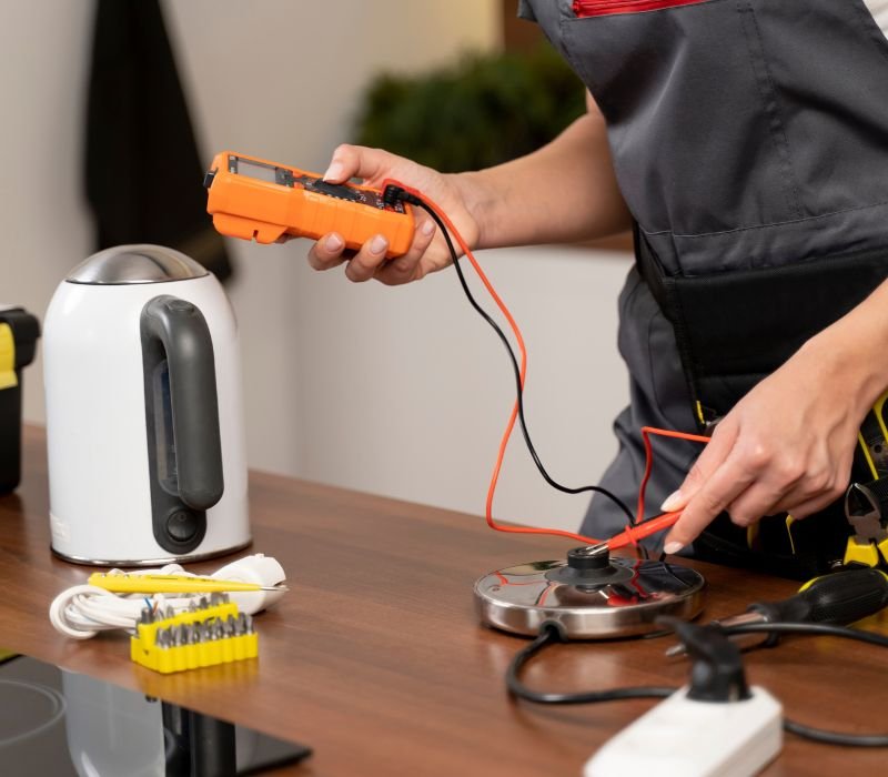 a male checking electrical kettle with tools