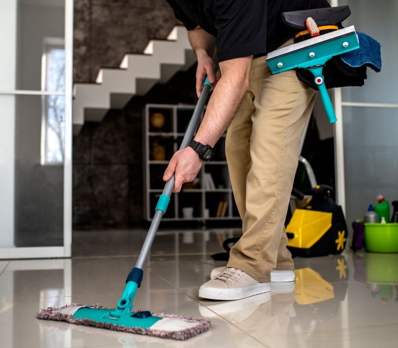 male cleaning floor with mop