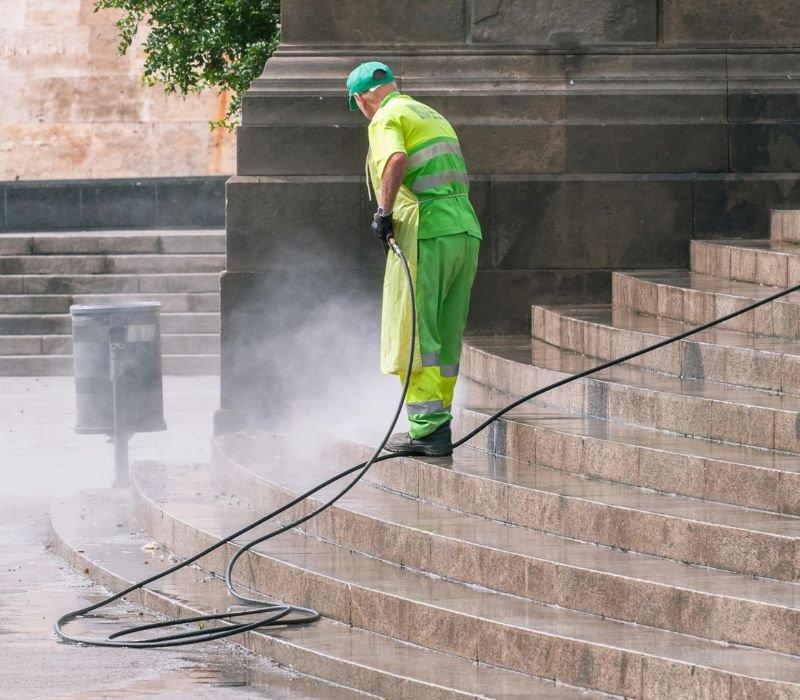 a man deep cleaning stairs with pressure water