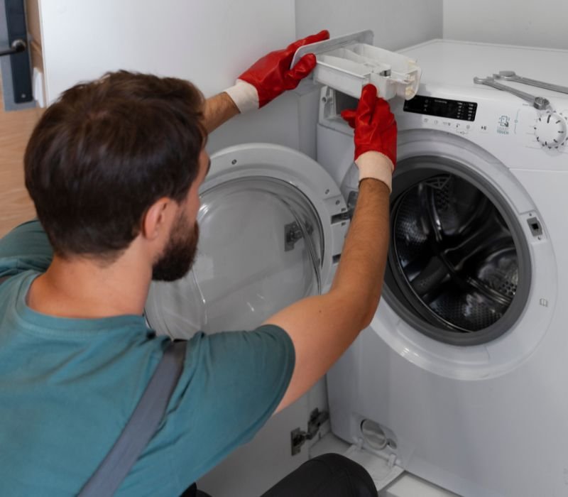 a boy with gloves repairing dryer