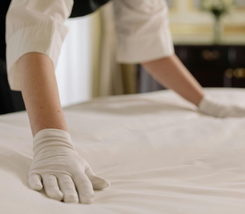 maid setting bed sheet with hands