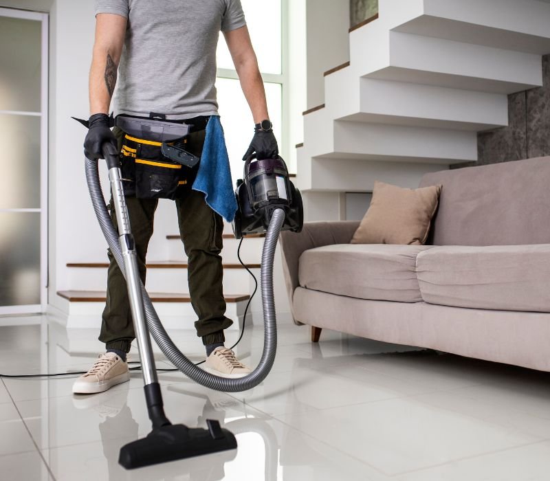 a boy cleaning home with vacuum cleaner