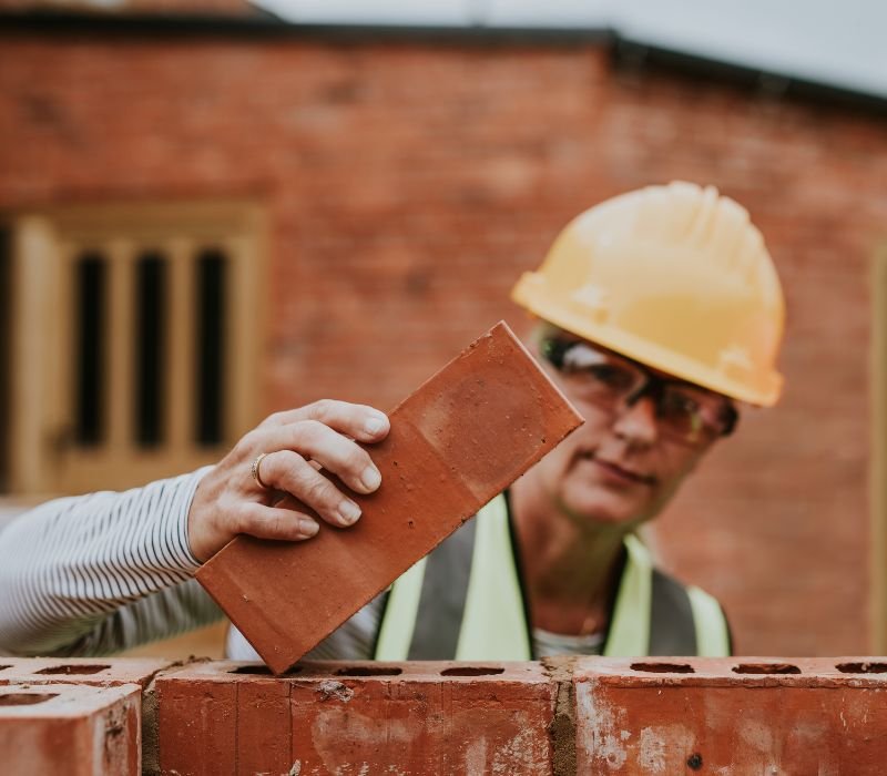 a mason laying bricks on the wall