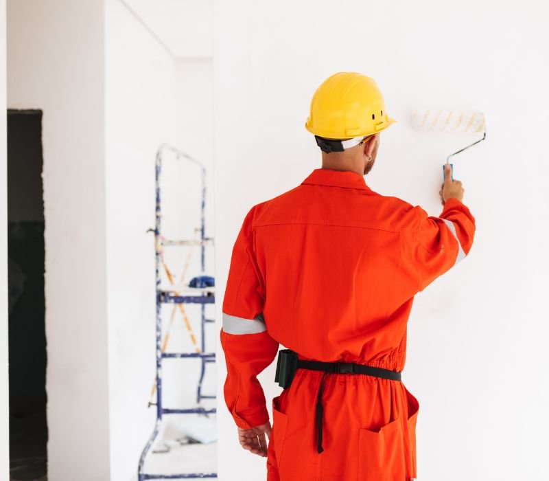 a professional painter painting wall with roller