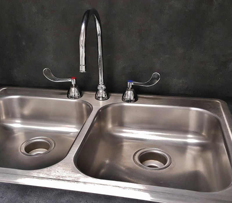 a sink with two separate tubs and single water tap